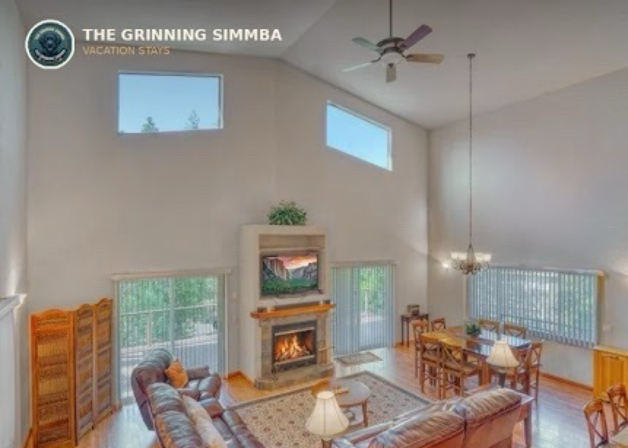 Vaulted Great Room with fireplace, leather seating, and dining area