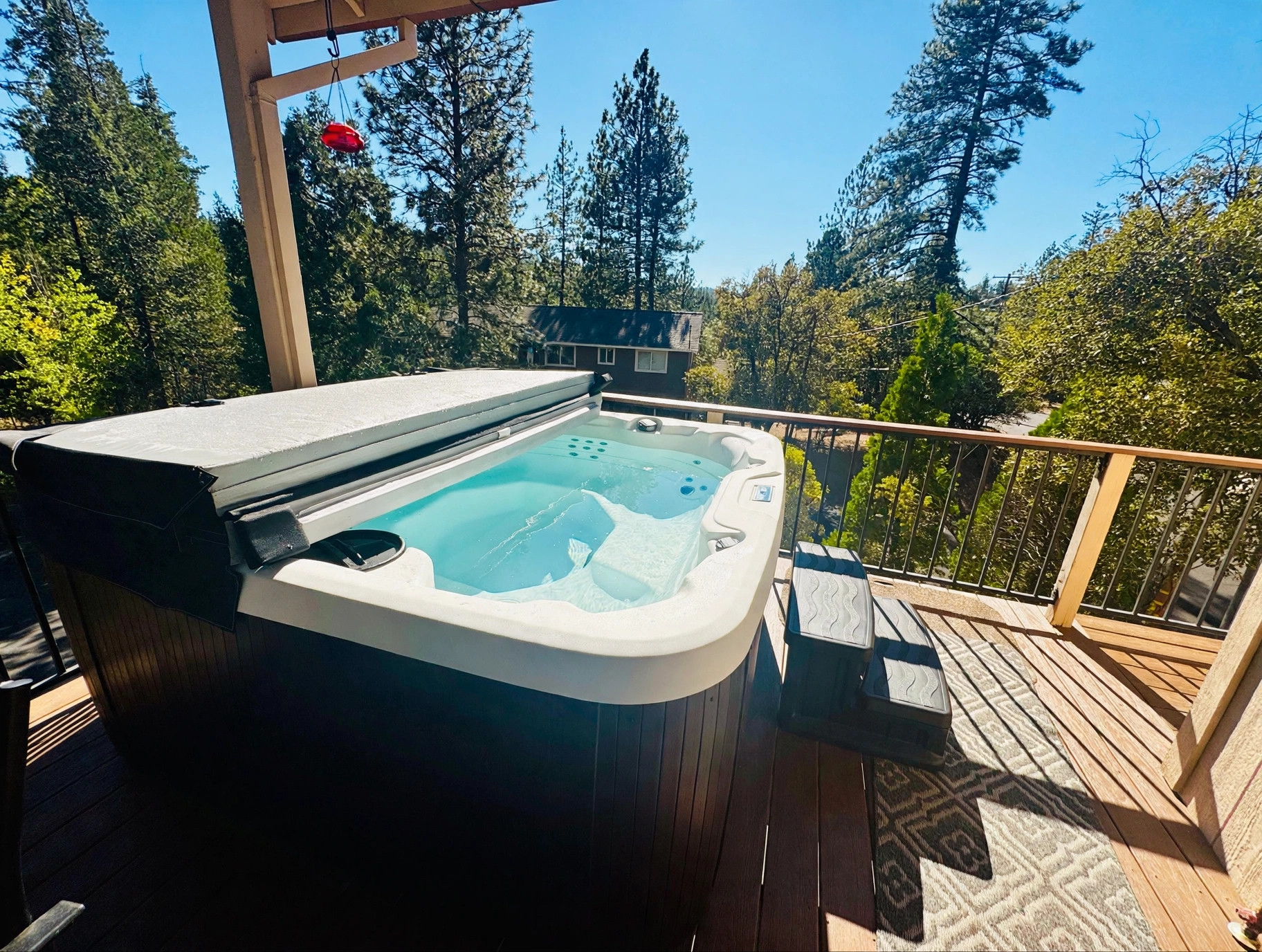 Hot tub on the cabin deck overlooking the surrounding pine forest
