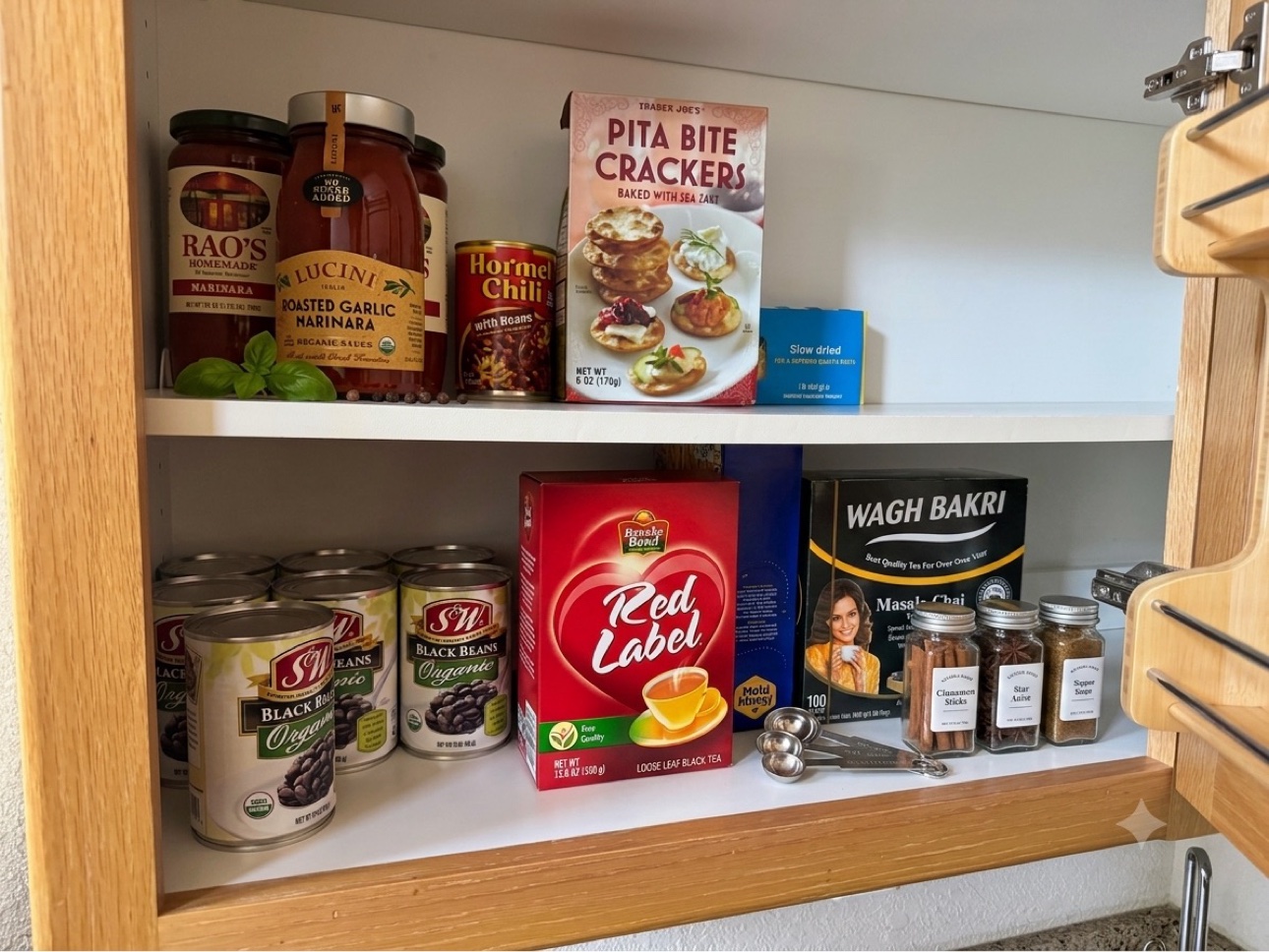 Kitchen pantry stocked with tea, beans, pasta sauce, and spices
